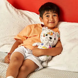 Child hugging Colour in Fairytale Artie Bear with colorful designs.