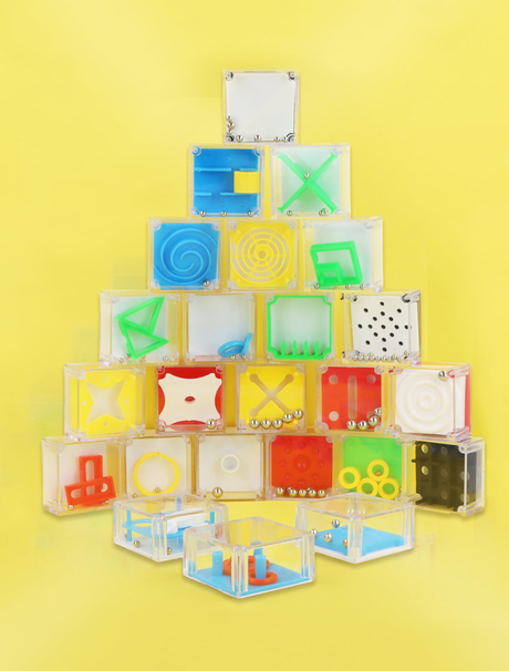Colorful single maze puzzle blocks with various designs stacked against a yellow background, ideal for brain teasers and party favors.