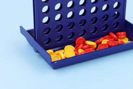 Travel size 4 in a row game with red and yellow pieces on blue background.